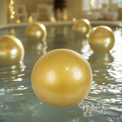 Golden inflatable beach balls floating in a serene pool setting.