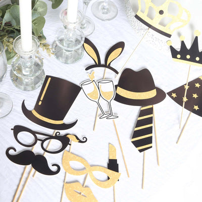 Party photo booth props in gold and black, including hats and masks.
