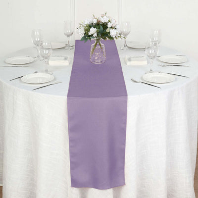 Purple table runner on a white table with floral centerpiece and dinnerware.