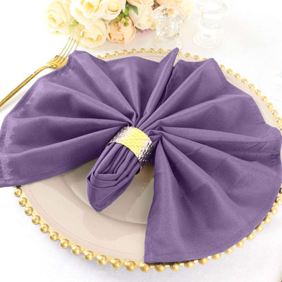 Purple napkin elegantly arranged on a decorative plate with a gold ring.