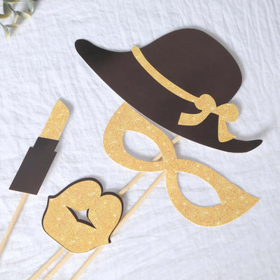 Party photo booth props including a hat, mask, lipstick, and lips in glittery finish.