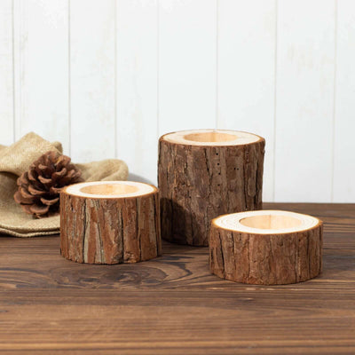 Rustic wooden candle holders in various sizes on a wooden table.