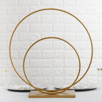 Gold circular decor stand on a table with plates and glassware.