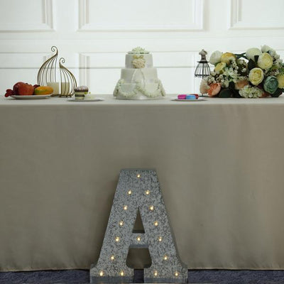 Decorative wedding cake display with floral arrangements and illuminated letter "A".