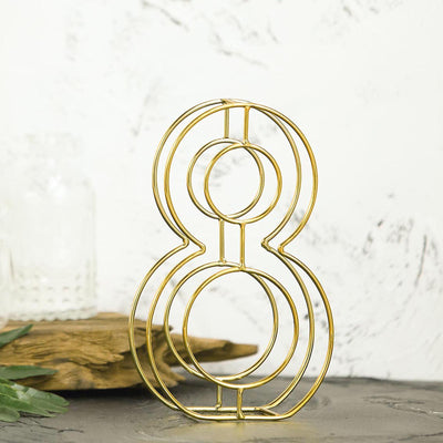 Gold wire number 8 decor on a textured surface.