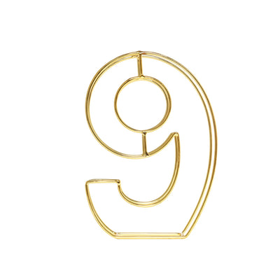 Gold wire number 9 decorative piece on a plain white background