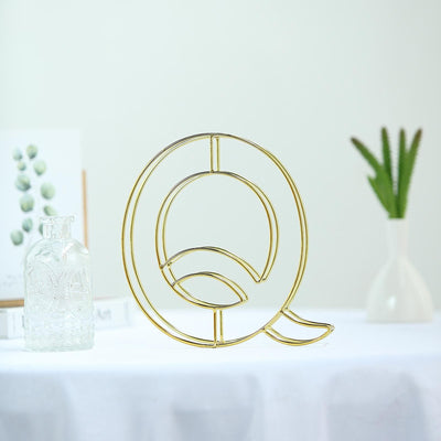 Gold wire letter Q decorative piece on a clean table setting.