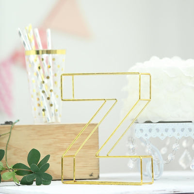 Gold wire letter "Z" decorative item on a table with party supplies.
