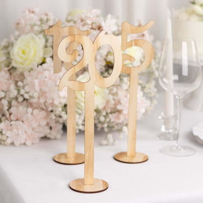 Wooden table numbers 205 on a decorated table with flowers and glassware.