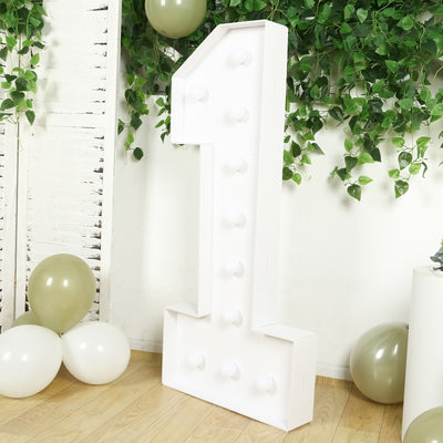 Large white marquee number one with light bulbs on a decorative background.