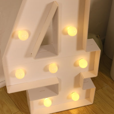 Illuminated marquee number 4 with light bulbs on a wooden floor.