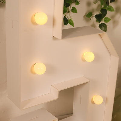 White letter "S" marquee light with yellow bulbs.