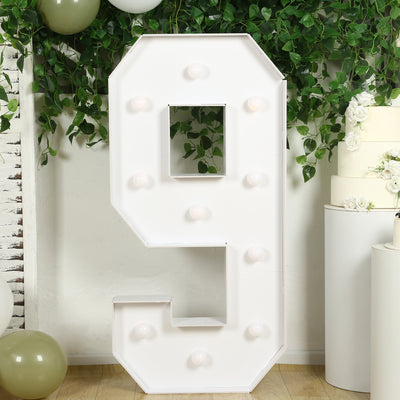 White marquee number 9 with light bulbs on a decorative backdrop.