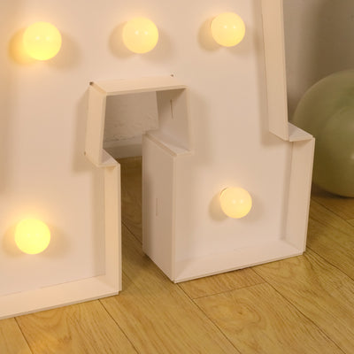 Decorative light-up letter with round bulbs on a wooden floor.