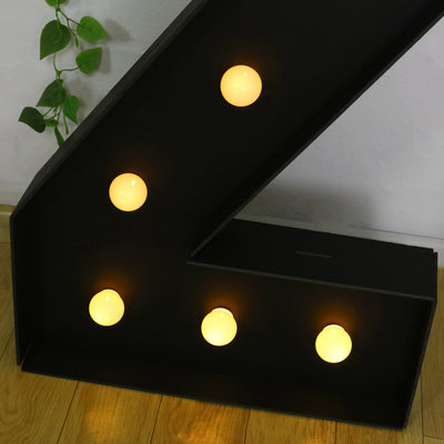 Black marquee letter "Z" with glowing yellow bulbs