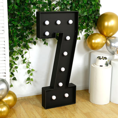 Large illuminated black number seven marquee sign with white bulbs.