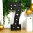 Large black marquee number 7 with white bulbs, decorated with greenery and balloons.