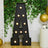 Decorative marquee letter A with lights and greenery backdrop