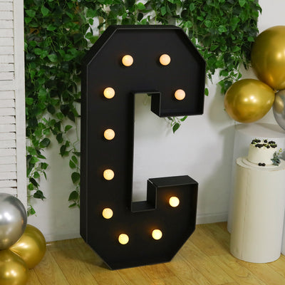 Large illuminated letter C with bulbs, perfect for decor or events.