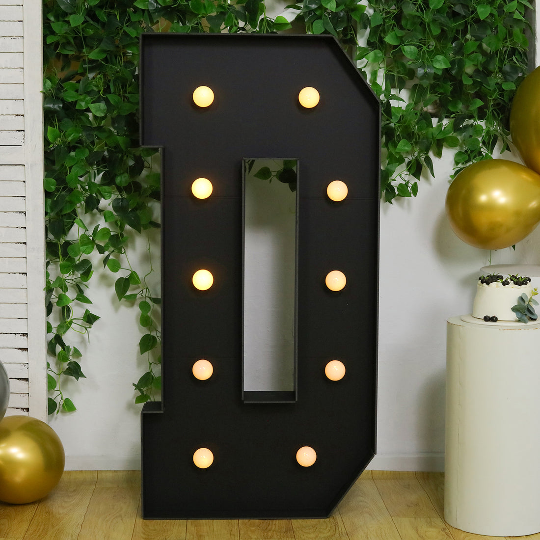 Large illuminated letter "D" with bulbs, set against a festive background.