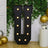 Large illuminated letter "U" marquee sign with bulbs, set against greenery.
