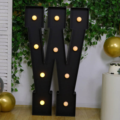Large black illuminated letter W marquee decoration with gold party accents