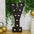 Large decorative letter "Y" with lights against a green plant backdrop.