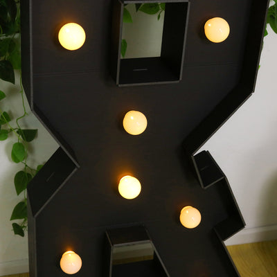 Black marquee number 8 with glowing bulbs against a green plant backdrop.