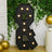 Black marquee number 8 with lights, set against greenery and gold balloons.