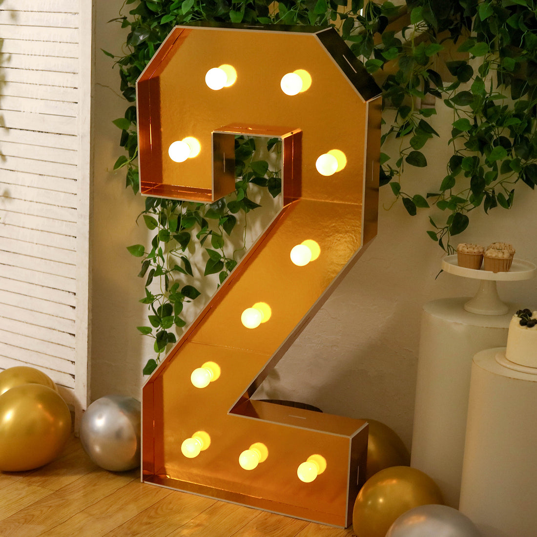 Gold marquee number two with lights, set against a festive backdrop.