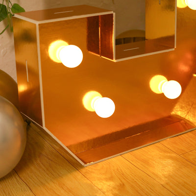 Gold decorative lamp with light bulbs, perfect for stylish home decor.