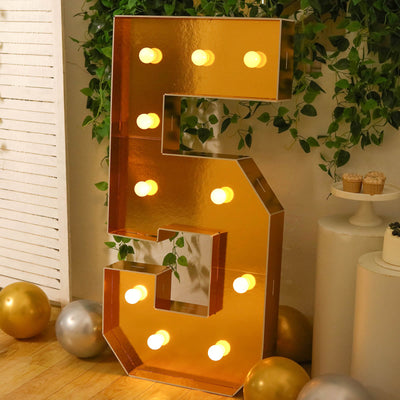Gold marquee letter S with lights in elegant party decor setting