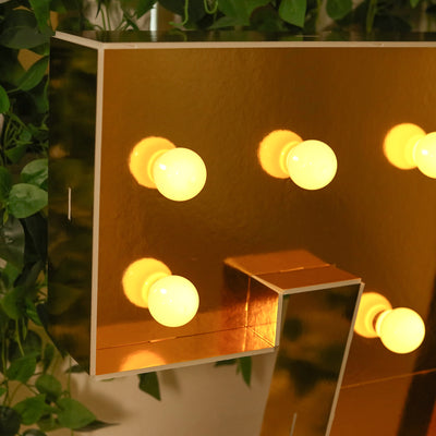 Gold marquee letter with glowing bulbs against a green background.
