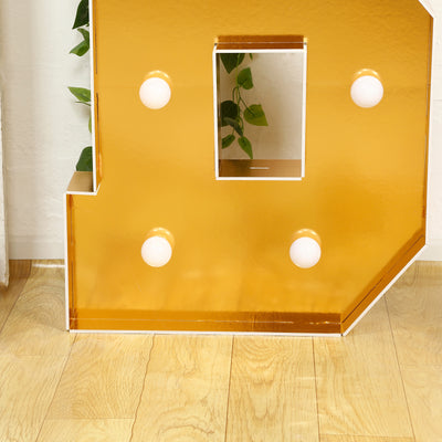 Gold marquee letter with lights and cutout for plants.
