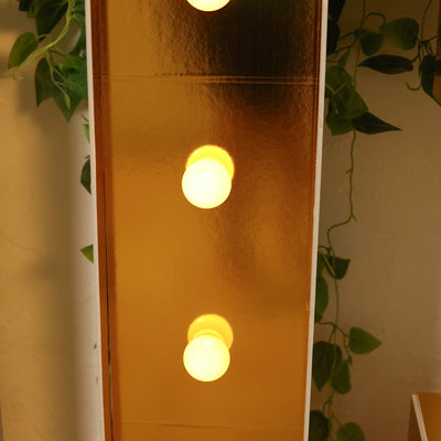 Gold decorative lamp with three round bulbs glowing softly.