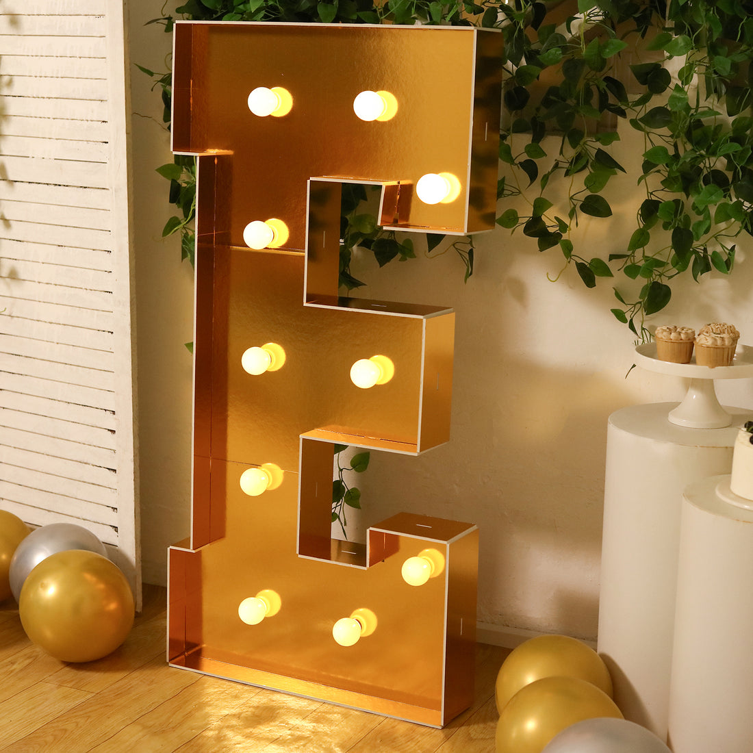 Gold marquee letter "E" with lights, perfect for events and celebrations.