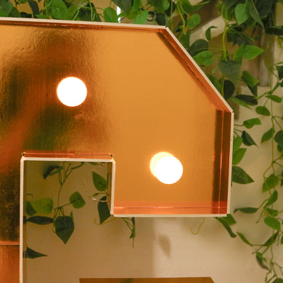 Copper letter light with round bulbs, perfect for home decor.