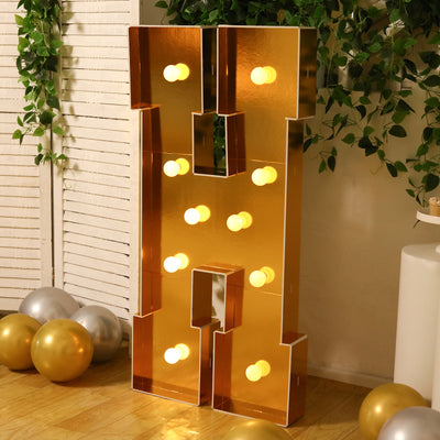 Large illuminated letter "H" in gold with bulbs on a festive background.