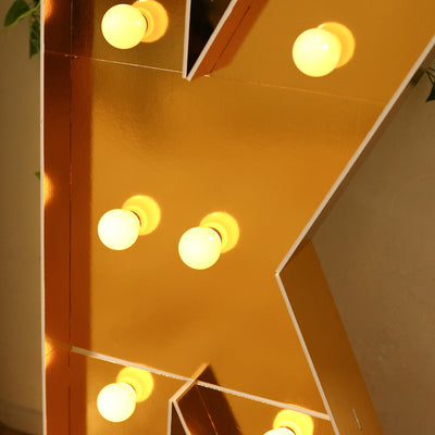 Gold marquee letter with vintage light bulbs.