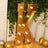 Gold marquee letter 'K' with lights, styled in a festive setting.