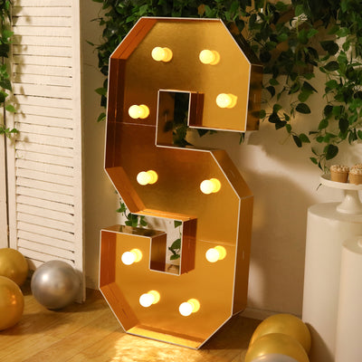 Gold marquee letter "S" with lights, perfect for events and decor.