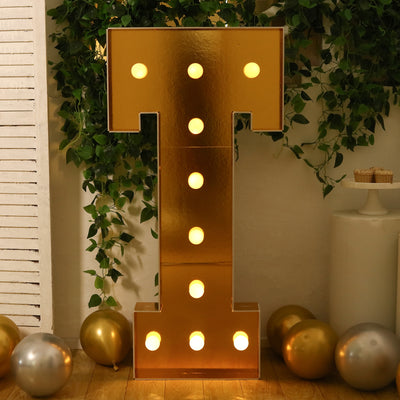 Gold marquee letter "T" with lights, perfect for parties and events.