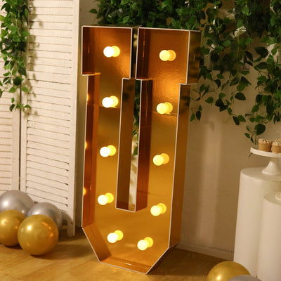 Gold marquee number 1 light decoration with warm bulbs and greenery
