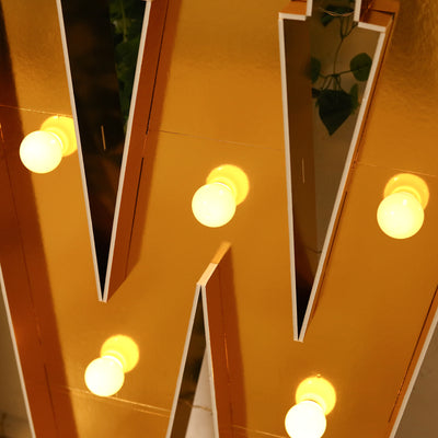 Gold marquee letter "W" with glowing bulbs, stylish decor accent.