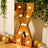 Gold marquee letter "X" with lights, decorated with balloons and greenery.