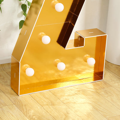 Gold marquee letter with lights on a wooden floor.