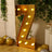 Gold marquee letter 'Z' with lights, styled in a festive setting.