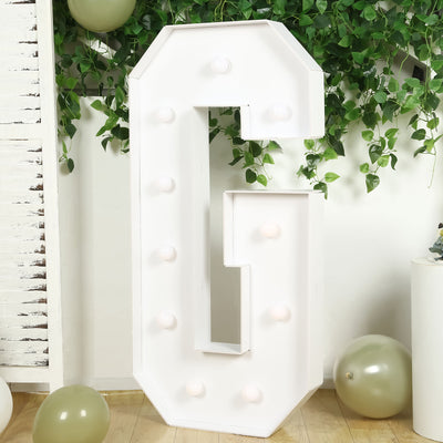 Large marquee letter "G" with lights on a white background