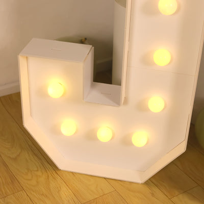 Illuminated marquee letter "J" with glowing bulbs on a wooden floor.