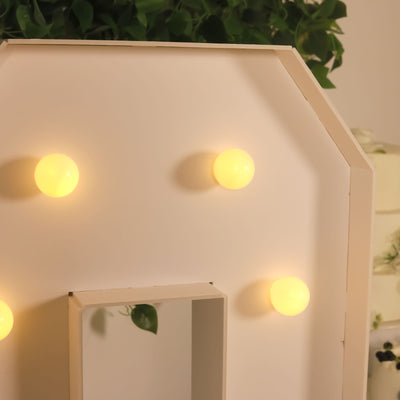 Decorative light-up sign with warm yellow bulbs on a white backdrop.